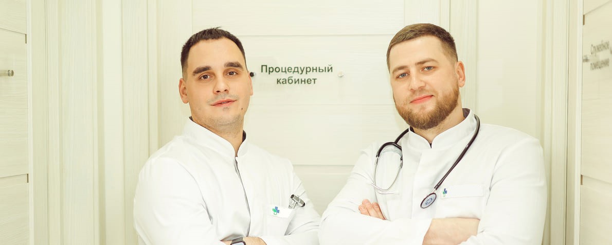 Два врача в белых халатах в коридоре клиники
